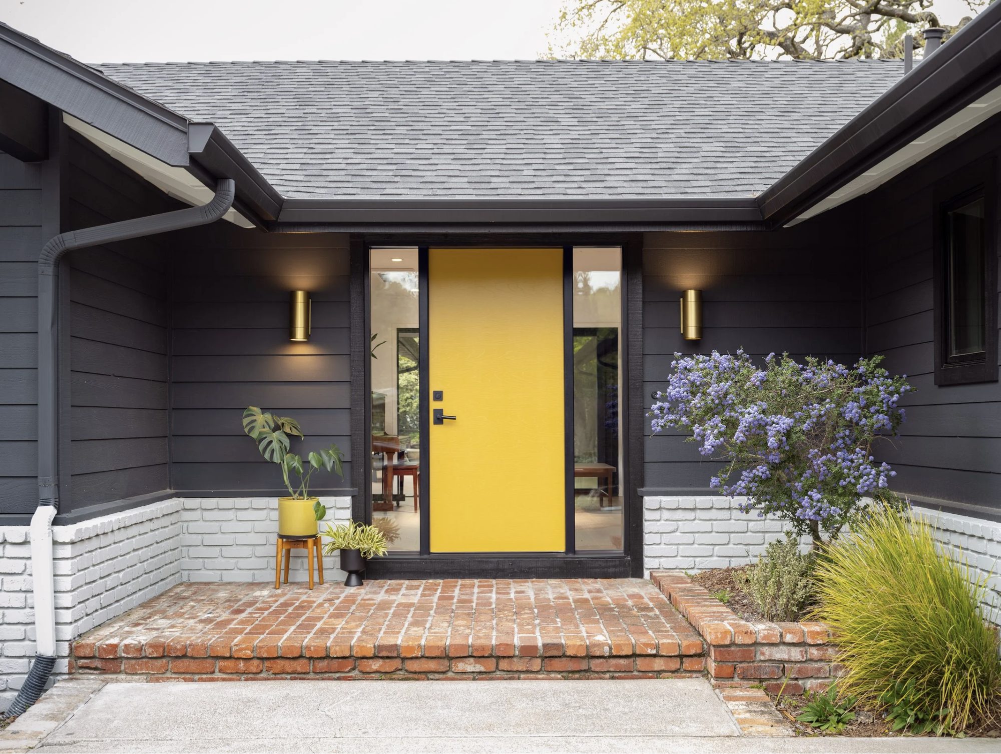 Mid-century entry with yellow door and painted-brick base